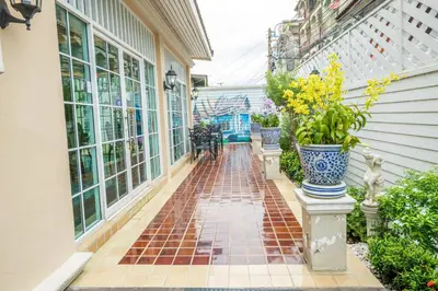 a porch with vases and a brick walkway at The Orchid House 153 in Bangkok