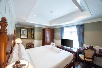 a bedroom with a bed and a desk and a television at The Orchid House 153 in Bangkok
