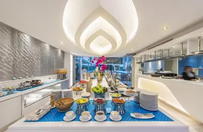 a dining room with a table with food on it at Le Tada Residence in Bangkok