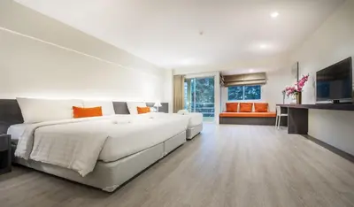 a large white bedroom with a large bed and a couch at Le Tada Residence in Bangkok