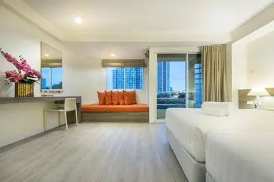 a hotel room with a bed and a couch at Le Tada Residence in Bangkok