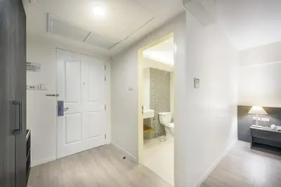 a bathroom with a white door and a sink at Le Tada Residence in Bangkok
