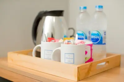 a wooden tray with cups on a kitchen counter at The Bedroom Ladprao 101 Bangkok - SHA in Bangkok