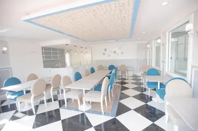 a dining room with tables and chairs on a checkered floor at The Bedroom Ladprao 101 Bangkok - SHA in Bangkok