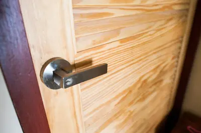 a wooden door with a metal door knocker on it at KENCOZY accommodation in Bangkok