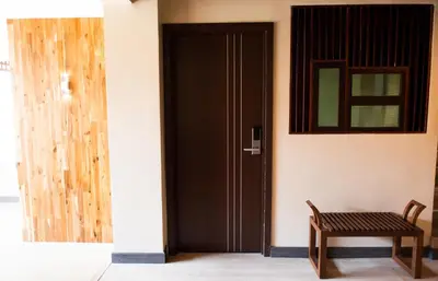 a wooden door in a room with a bench at KENCOZY accommodation in Bangkok