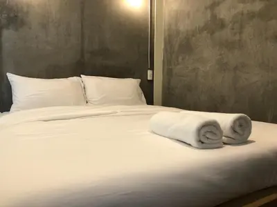 a white bed with towels on top of it at On the Bed Hostel in Bangkok