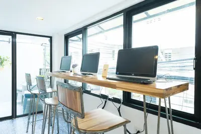 an office with a desk with a laptop and chairs at White Ivory Bed And Breakfast in Bangkok