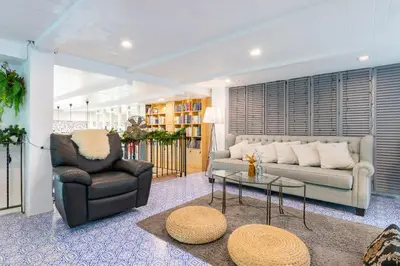a living room with a couch and a chair and a table at White Ivory Bed And Breakfast in Bangkok