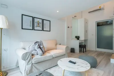a living room with a couch and a table at White Ivory Bed And Breakfast in Bangkok