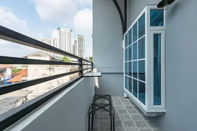 a balcony with a bench and a window at White Ivory Bed And Breakfast in Bangkok