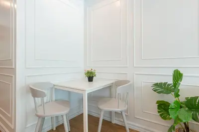 a white room with a table and two chairs at White Ivory Bed And Breakfast in Bangkok