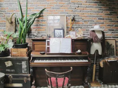 an old piano sitting next to a brick wall at J No.14 in Bangkok