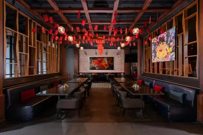 a dining room with tables and chairs and chandeliers at Metropole, Bangkok, a Tribute Portfolio Hotel by Marriott in Bangkok