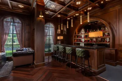 a bar with stools in a room with wooden walls at Metropole, Bangkok, a Tribute Portfolio Hotel by Marriott in Bangkok
