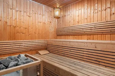 a wooden sauna with benches and a chandelier at Metropole, Bangkok, a Tribute Portfolio Hotel by Marriott in Bangkok