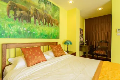 a bedroom with a bed with a painting on the wall at Nine Design Place in Bangkok