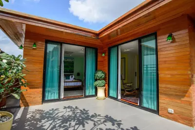a house with glass doors and a potted plant at Nine Design Place in Bangkok
