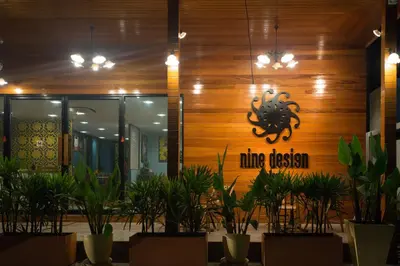 a restaurant with plants in front of a building at Nine Design Place in Bangkok