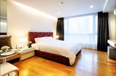 a bedroom with a bed and a desk and a window at Luxury Suite @ BTS Nana in Bangkok