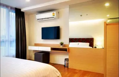 a bedroom with a bed and a flat screen tv at Luxury Suite @ BTS Nana in Bangkok