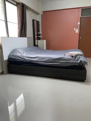 a bed sitting in a room with a window at Gedkanok Apartment in Bangkok