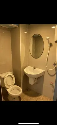 a bathroom with a toilet and a sink and a mirror at Gedkanok Apartment in Bangkok