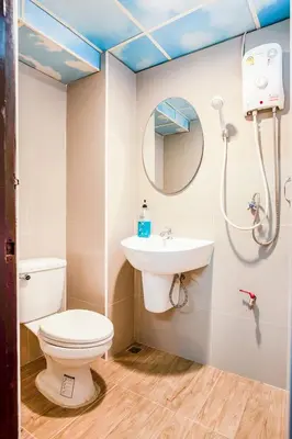 a bathroom with a toilet and a sink and a mirror at Gedkanok Apartment in Bangkok