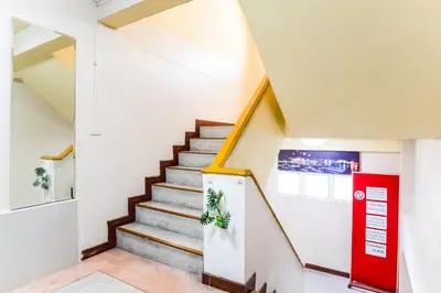 a staircase in a house with a red door at Gedkanok Apartment in Bangkok