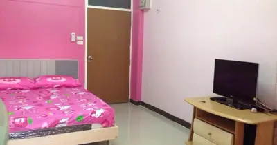 a bedroom with a bed and a desk with a computer at Gedkanok Apartment in Bangkok