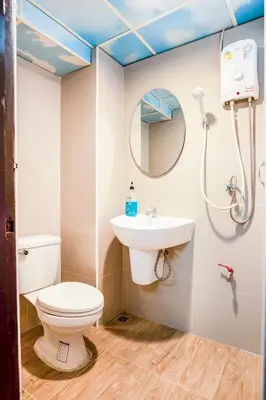 a bathroom with a toilet and a sink at Gedkanok Apartment in Bangkok