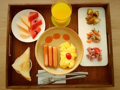 a tray with a plate of breakfast food and a drink at Zenniq in Bangkok