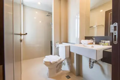 a bathroom with a toilet and a sink and a shower at Zenniq in Bangkok