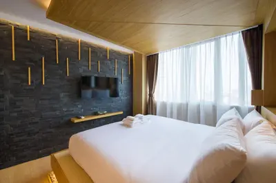 a hotel room with a bed and a tv at Zenniq in Bangkok