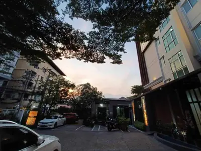 a city street with cars parked in a parking lot at Collection O The Bangkok Cha Cha Suite in Bangkok