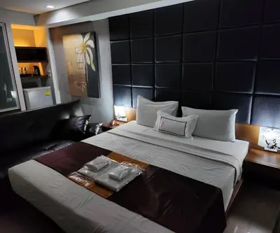a bedroom with a large bed and a couch at Collection O The Bangkok Cha Cha Suite in Bangkok