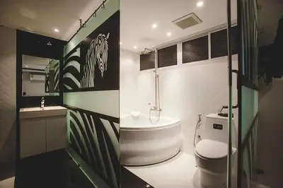 a bathroom with a tub and a toilet and a sink at Double Five in Bangkok
