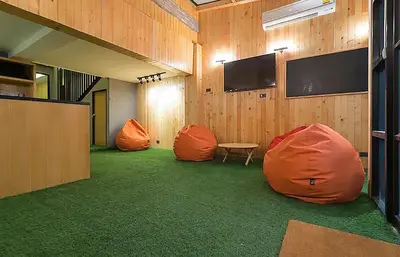 a room with two orange bean bags and a table at Double Five in Bangkok
