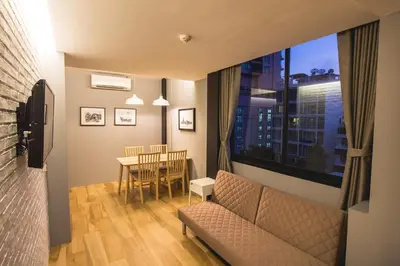 a living room with a couch and a table and a window at Sleep Box Hotel Sukhumvit 22 in Bangkok