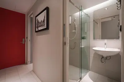 a bathroom with a sink and a glass shower at Sleep Box Hotel Sukhumvit 22 in Bangkok