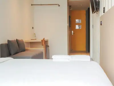 a room with a bed and a couch and a table at Sleep Box Hotel Sukhumvit 22 in Bangkok