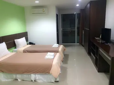 a hotel room with two beds and a television at Diamond Bangkok Apartment in Bangkok