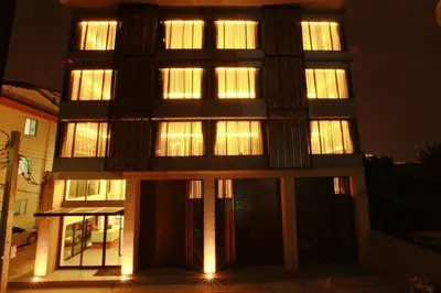 a tall building with lights on it at night at The Bangkok Major Suite in Bangkok