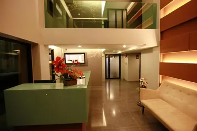 a lobby with a reception desk and a couch at The Bangkok Major Suite in Bangkok