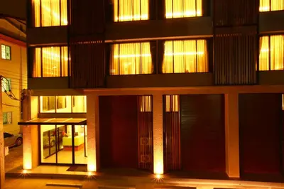 a building with lit up windows and doors at night at The Bangkok Major Suite in Bangkok