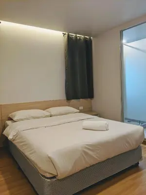 a large bed in a bedroom with a window at Good One Poshtel & Cafe Bar in Bangkok