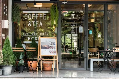 a coffee and tea shop with a sign in the window at Good One Poshtel & Cafe Bar in Bangkok