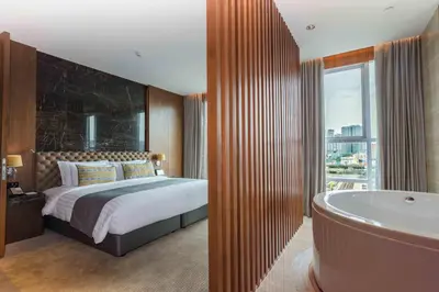 a bedroom with a bed and a bath tub and a tub at Lancaster Bangkok in Bangkok