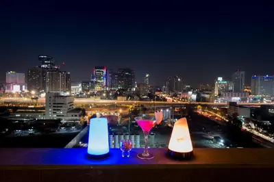 a view of a city at night with two glasses of wine at Lancaster Bangkok in Bangkok