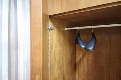 a pair of shoes hanging from a wooden door at Kim Hotel At Bangplong in Bangkok